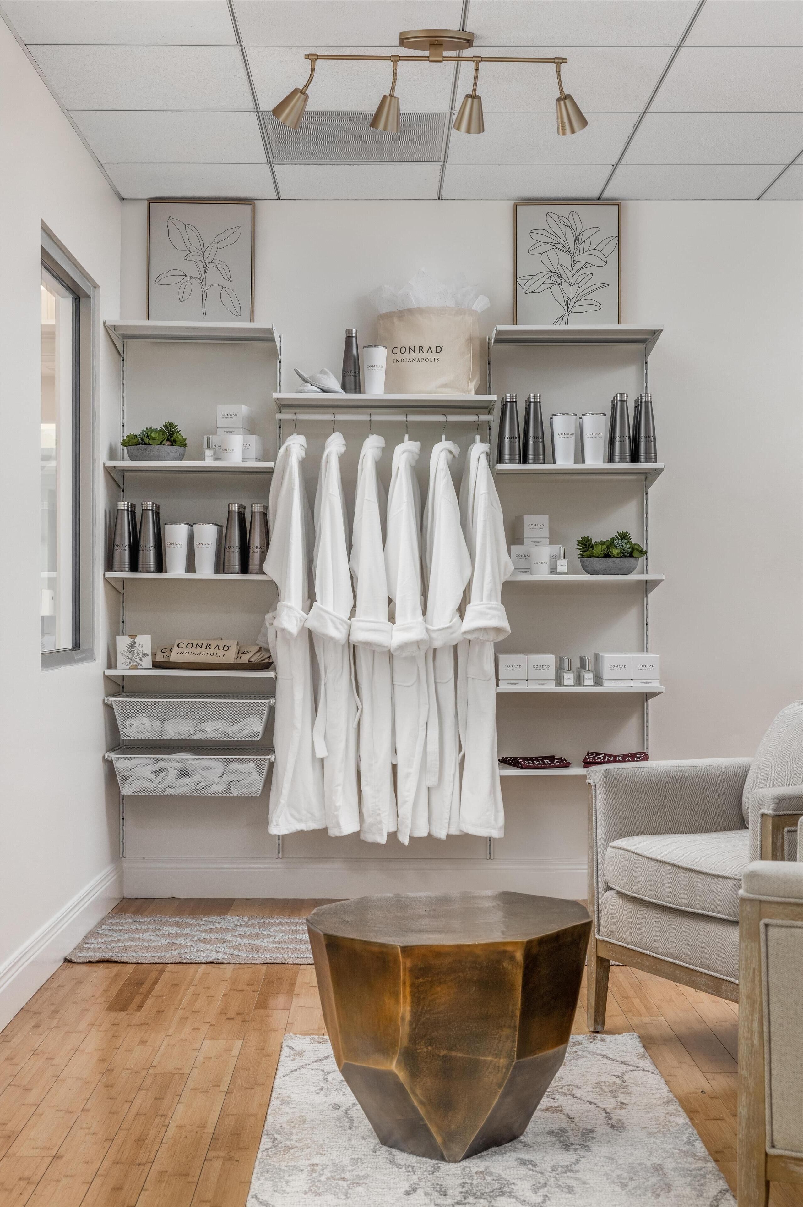 Un baño moderno con estantes blancos, zona de ducha y suelo de madera.