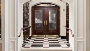 A grand entrance with a checkered floor, double doors, and a sign reading 'THE CAPITAL GRILLE'. - Conrad Indianapolis (Indianapolis)