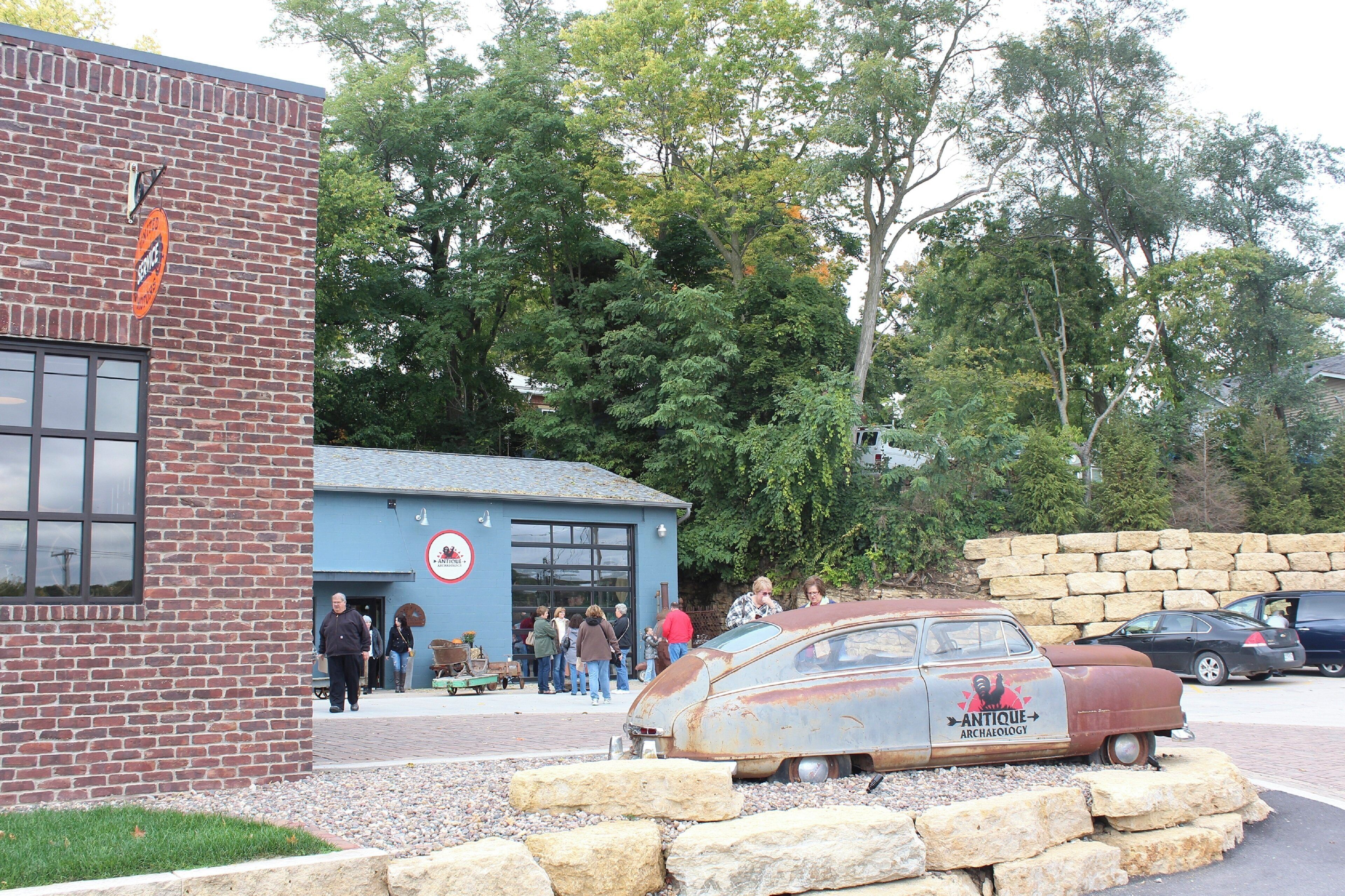 A brick building with a blue door and a sign that reads 'ANTIQUE ARCHAEOLOGY'.