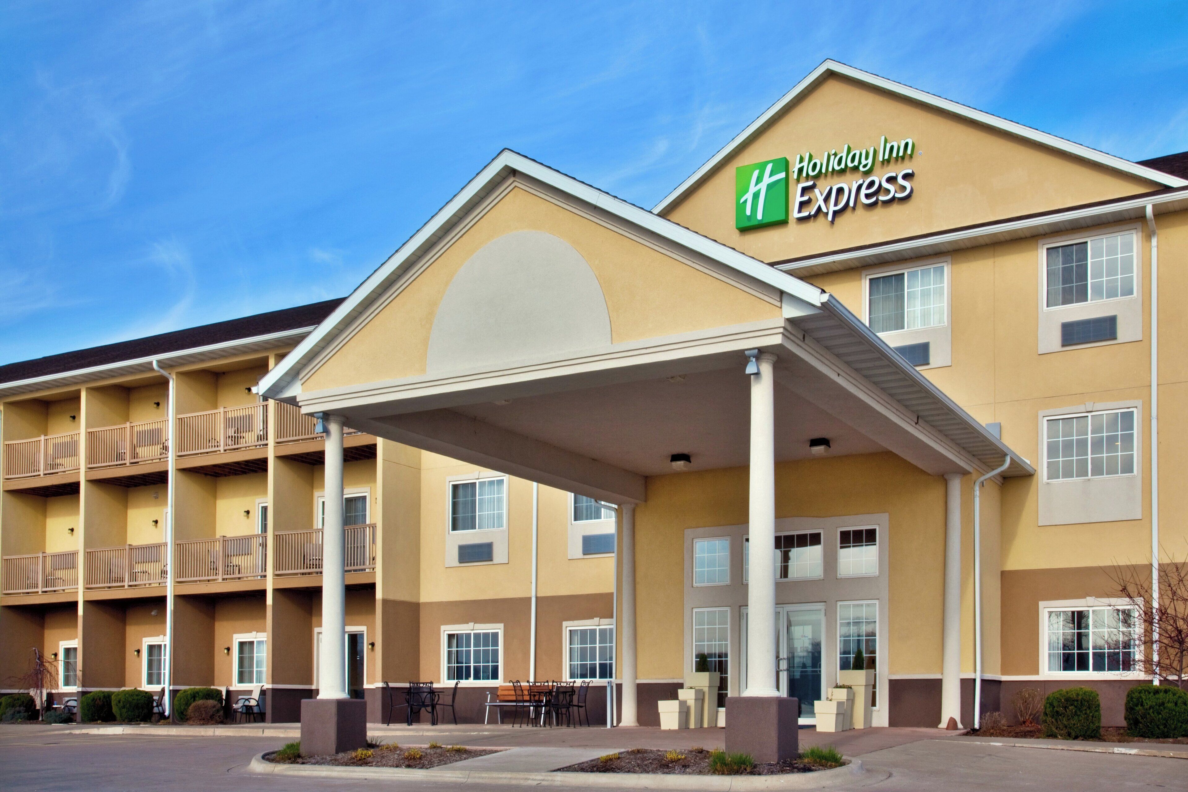 A Holiday Inn Express building with a covered entrance, multiple balconies, and a parking lot.