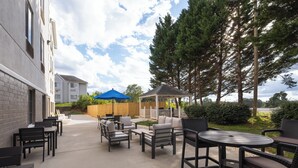 An outdoor patio area with seating and a gazebo. - Holiday Inn Express Charlotte West - Gastonia by IHG. (Gastonia)