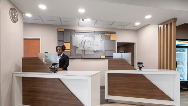 A reception area with two counters, a clock on the wall, and a sign that reads "HP Express". - Holiday Inn Express Charlotte West - Gastonia by IHG. (Gastonia)