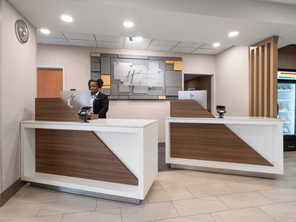 A reception area with two counters, a clock on the wall, and a sign that reads "HP Express". - Holiday Inn Express Charlotte West - Gastonia by IHG. (Gastonia)