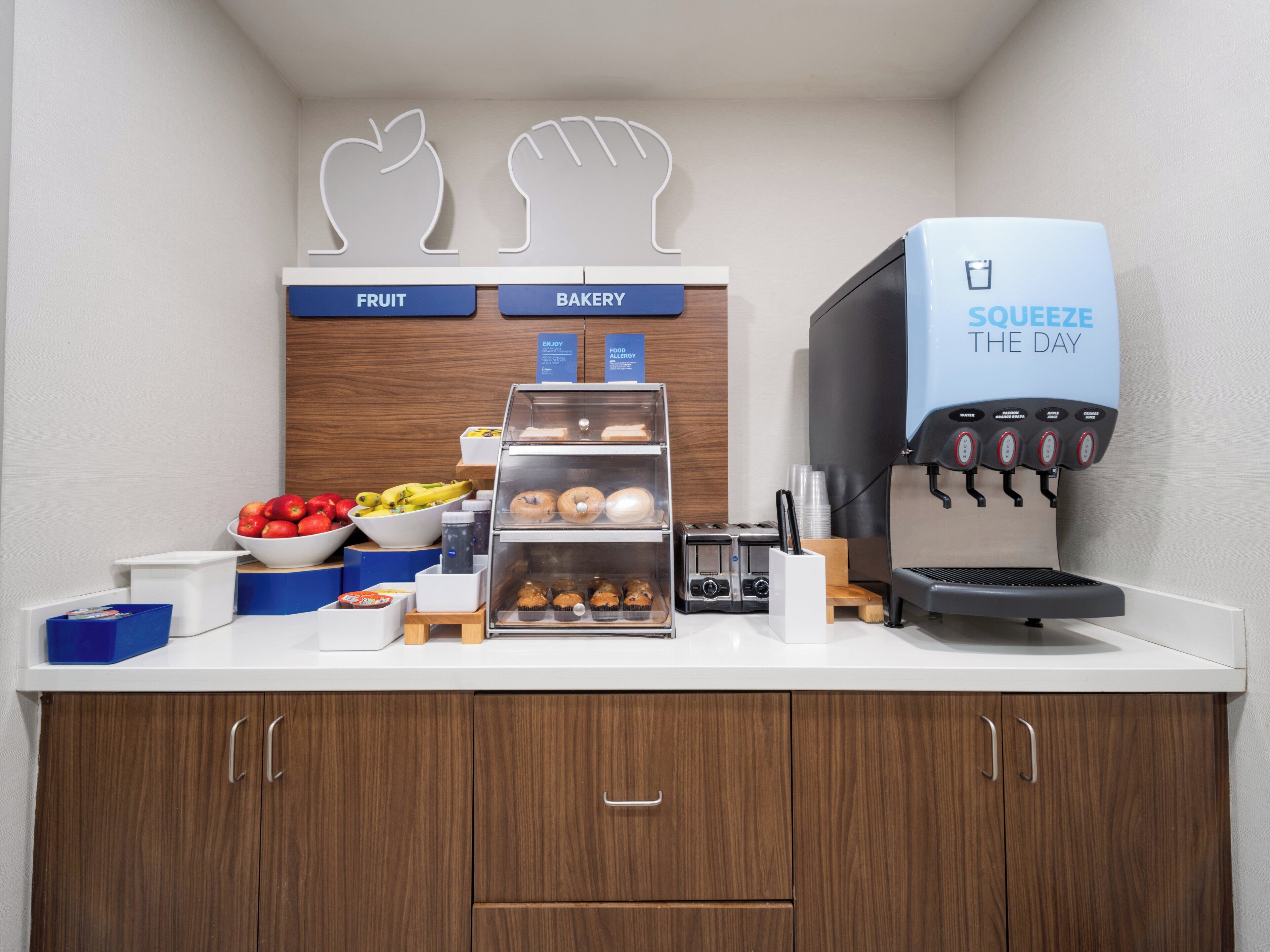 Un buffet pour le petit-déjeuner proposant des fruits, des viennoiseries, une machine à café et un saladier de produits frais.