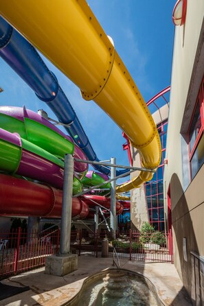 A water park with multiple colorful water slides and a pool area.