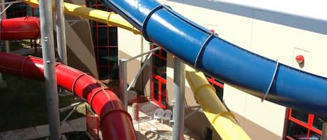 A multi-colored water slide structure with a building in the background.