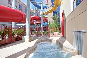 A water park area with multiple water slides and a hot tub. - Triple Play Resort Hotel & Suites (Hayden)