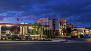 A hotel with a prominent sign, a covered parking area, and a well-lit entrance. - Hampton Inn & Suites Carson City (Carson City)