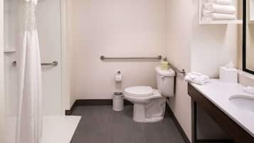 Un baño moderno con inodoro, bidé y tocador con espejo.
