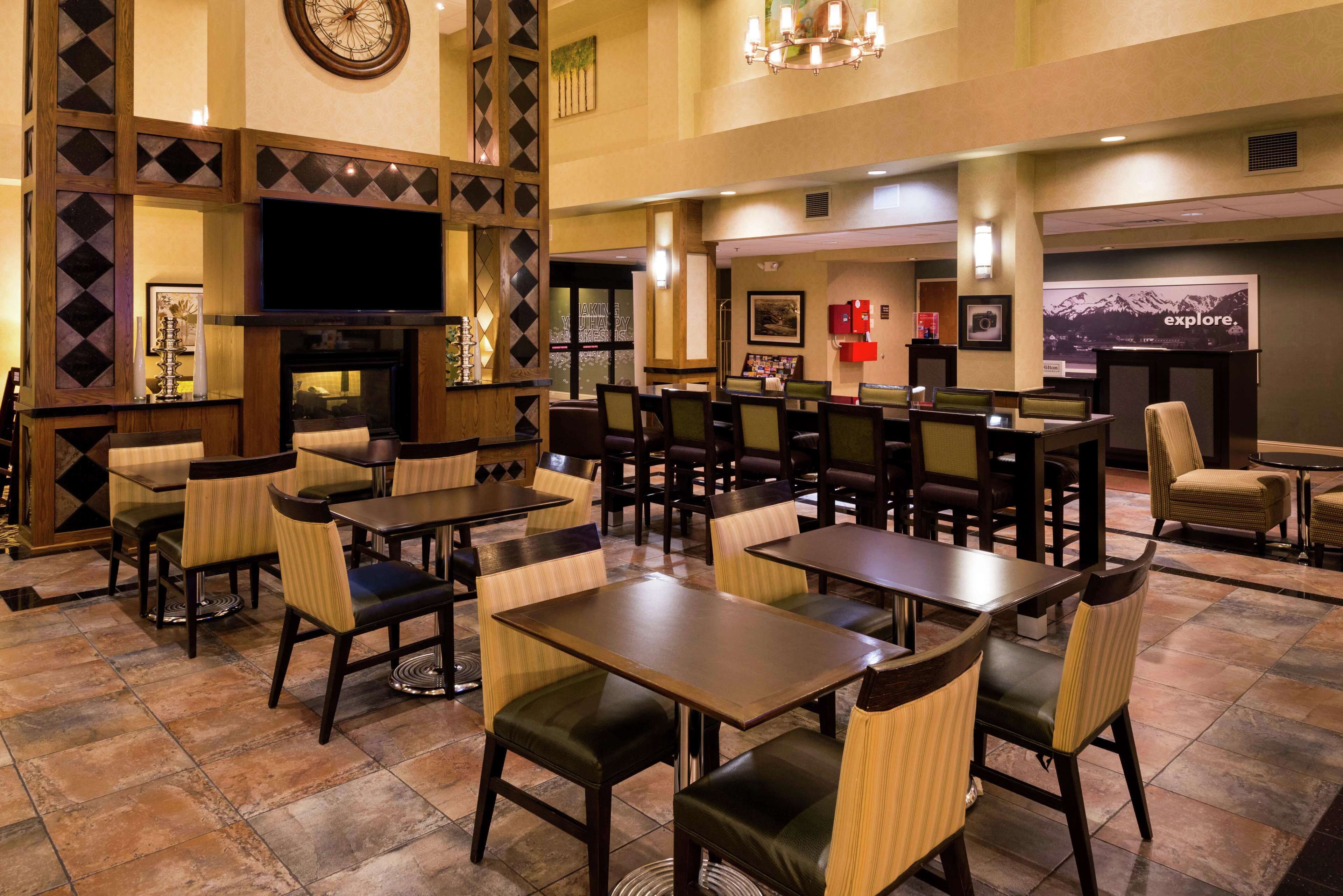 A restaurant with multiple tables and chairs, a television, and framed pictures on the walls.