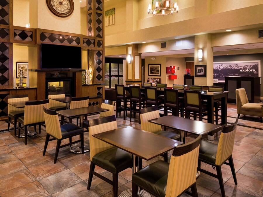 A restaurant with multiple tables and chairs, a television, and framed pictures on the walls.