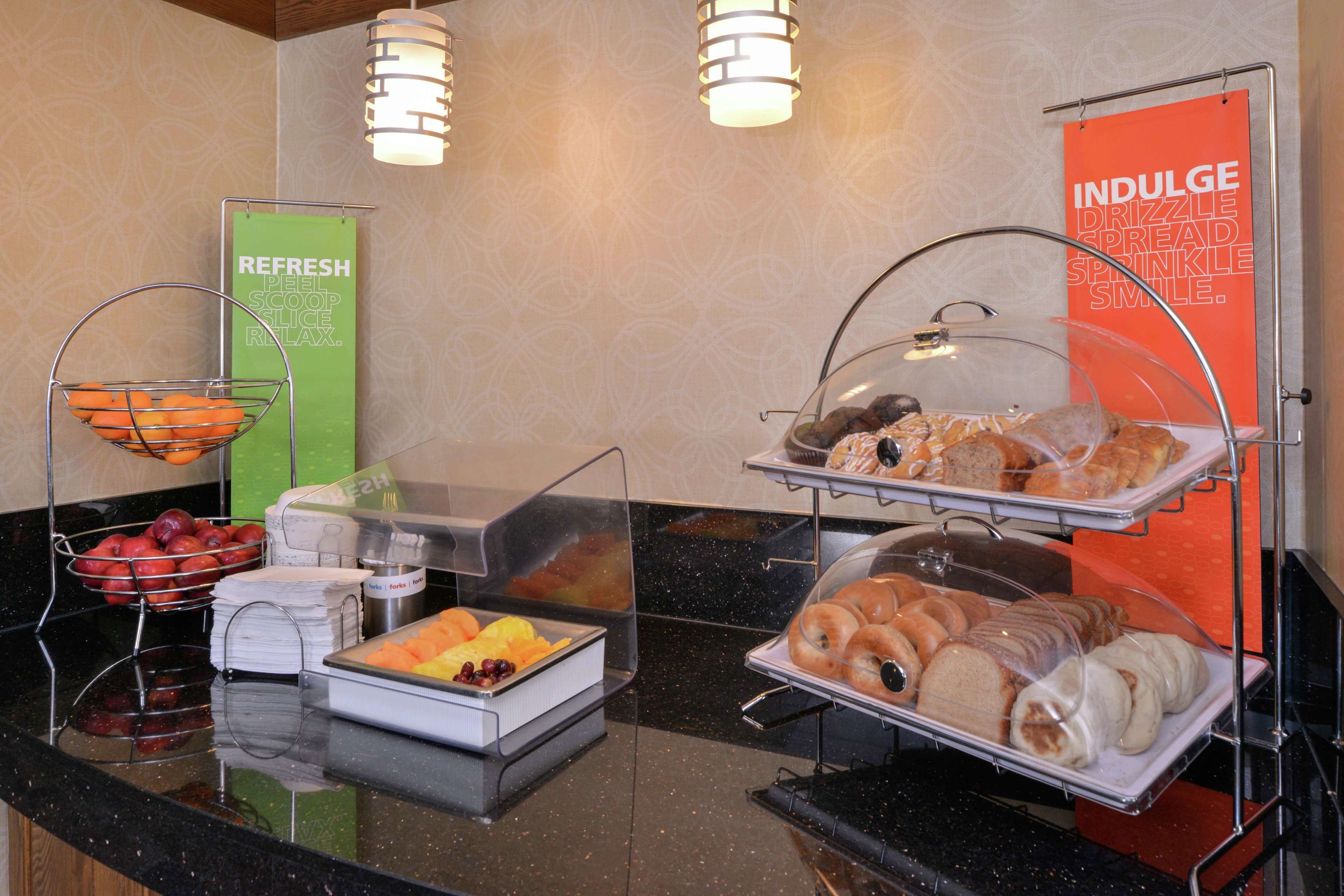Um buffet com diversos pratos e um letreiro com a inscrição "INDULGE DRIZZLE SPREAD SMILE".
