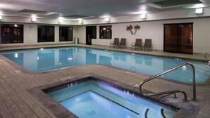 A swimming pool with a hot tub, lounge chairs, and a wooden door. - Hampton Inn & Suites Carson City (Carson City)