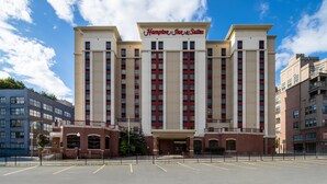 A large, multi-story hotel with a prominent sign reading 'Hampton Inn & Suites'.