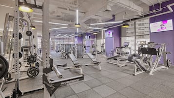 A gym with various exercise equipment, including weight machines and free weights.
