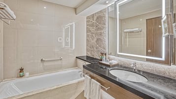 A modern bathroom with a bathtub, a vanity with a mirror, and a shower area.