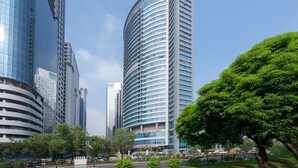 Een modern gebouw met een golvende gevel, grote ramen en een opvallend bord met Crowne Plaza erop.