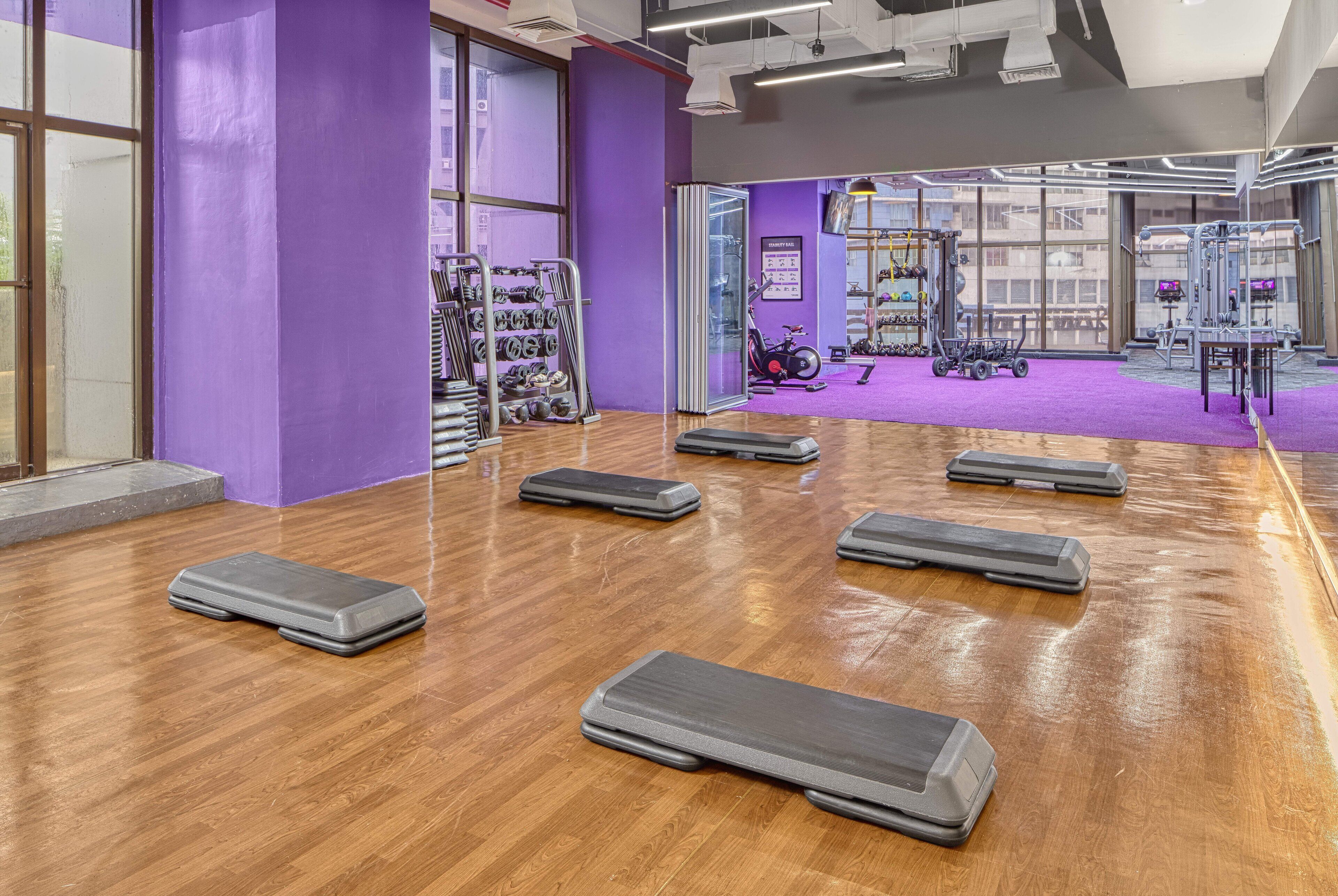 Un gimnasio con cintas de correr, pesas y equipo de ejercicio.