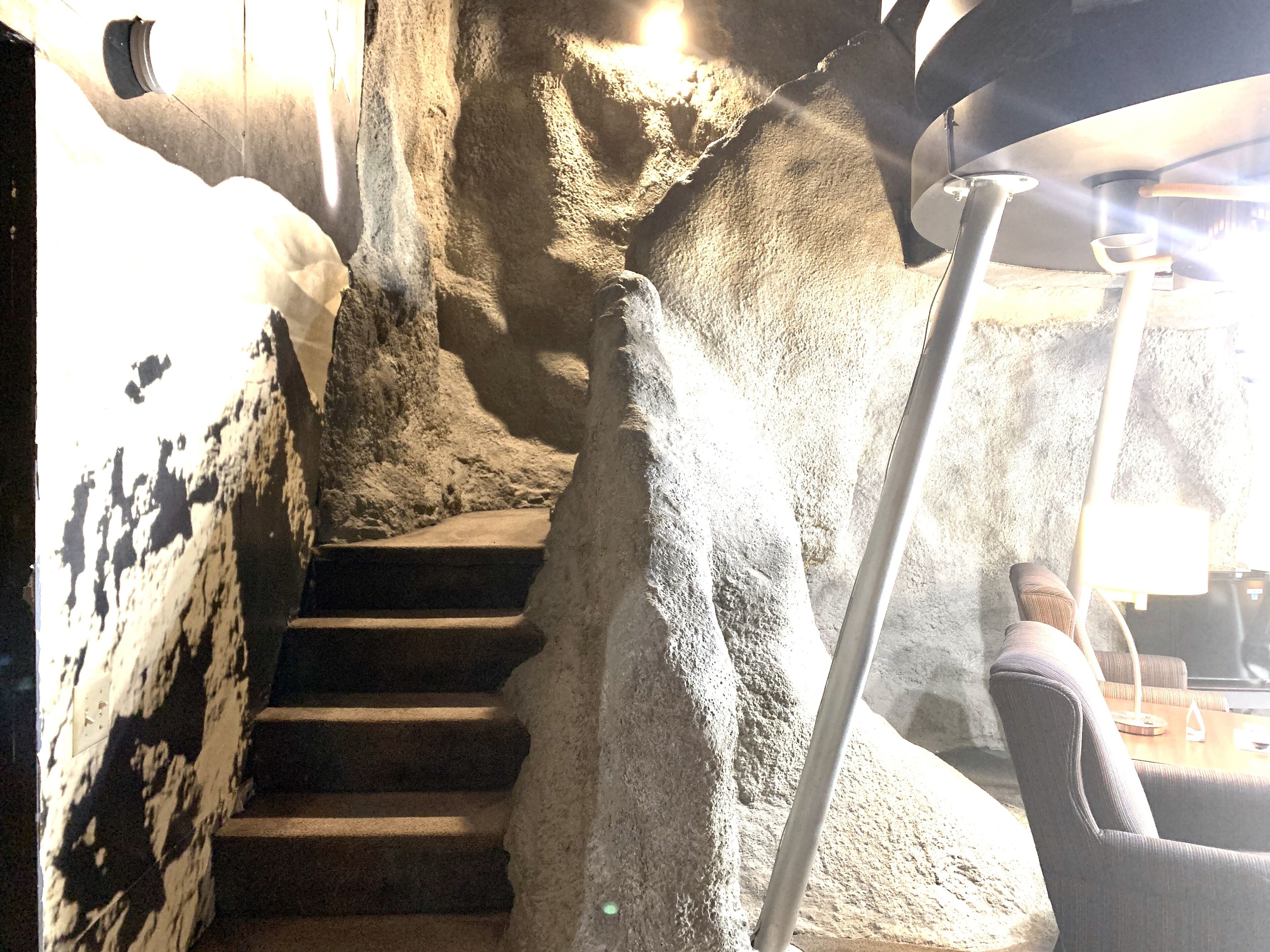 Un escalier avec des murs et des marches en pierre, montant vers le haut.