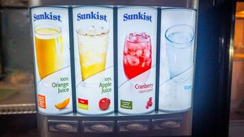 Ein Getränkeautomat mit vier Auswahlmöglichkeiten: Orangensaft, Apfelsaft, Cranberry-Saft und Wasser.