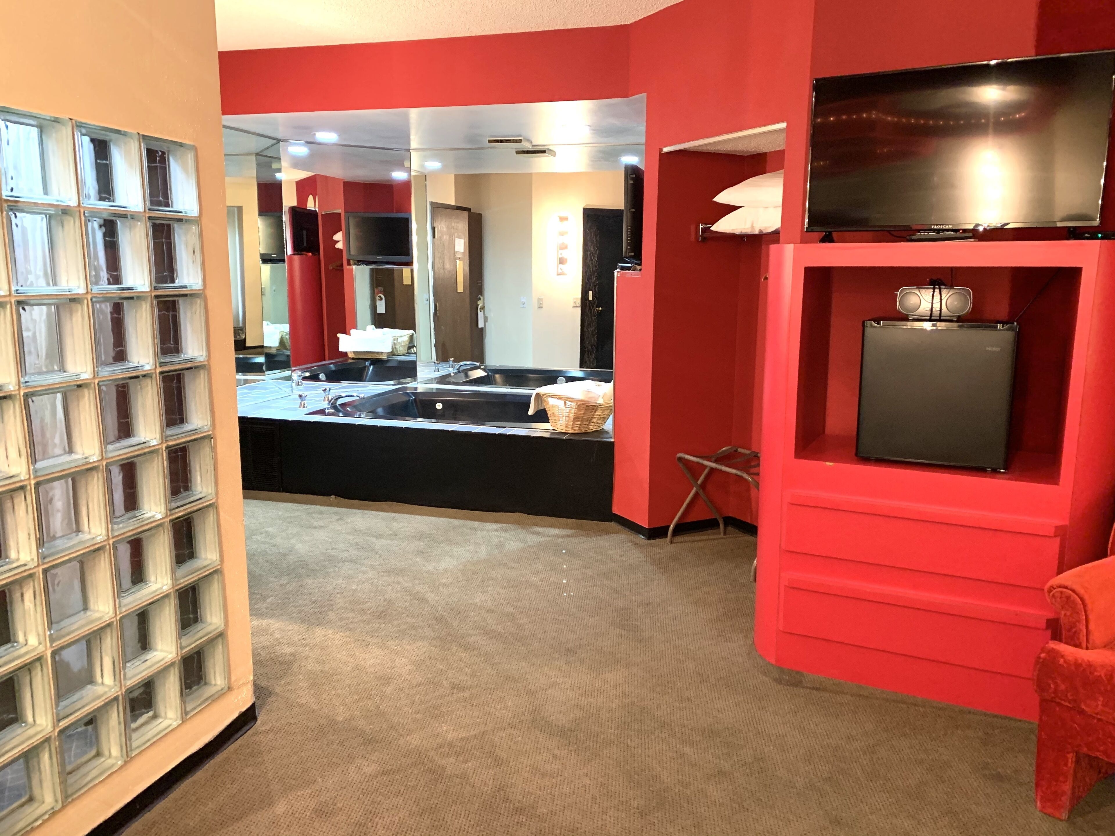 A modern kitchen with a central island, red walls, and a large window.