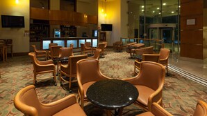 Et hotel lobby med barområde, siddepladser og et mønstret tæppe.