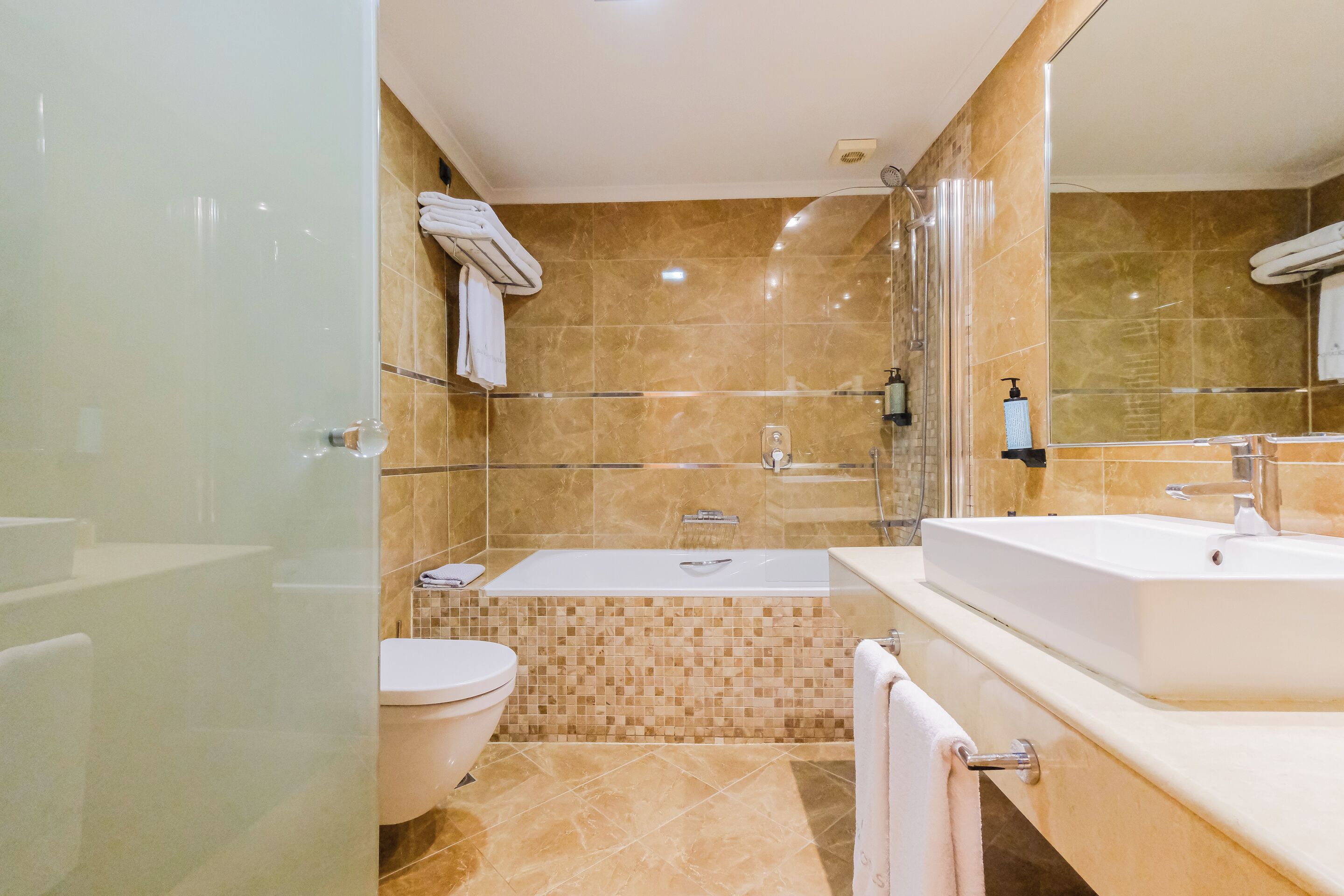 Une salle de bain moderne dotée d’une douche à parois de verre, d’une baignoire séparée et d’un meuble-lavabo avec un évier.