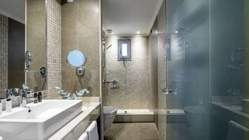 A modern bathroom with a large sink, mirror, and shower area.
