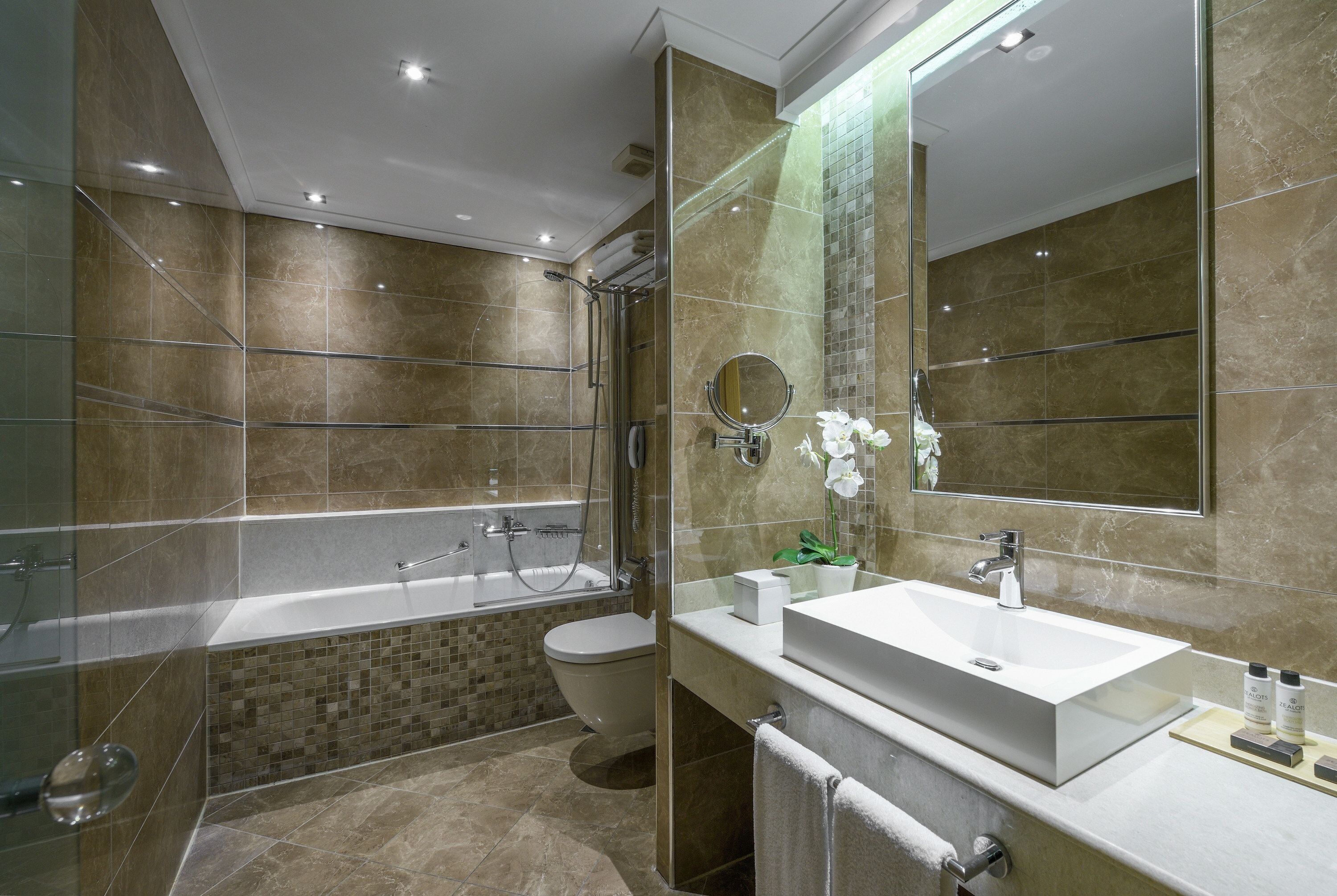 Een moderne badkamer met een bad, toilet en wastafel.