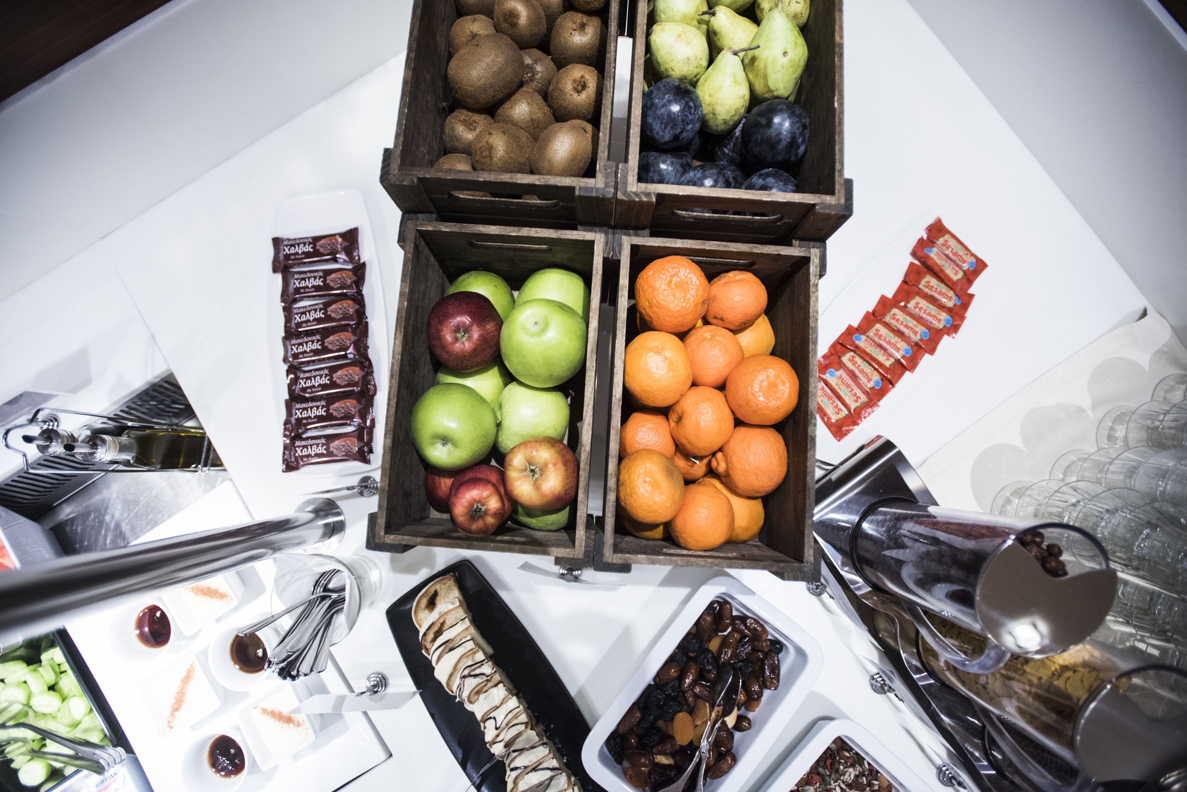 A table with various fruits and snacks, including apples, oranges, pears, and kiwis.