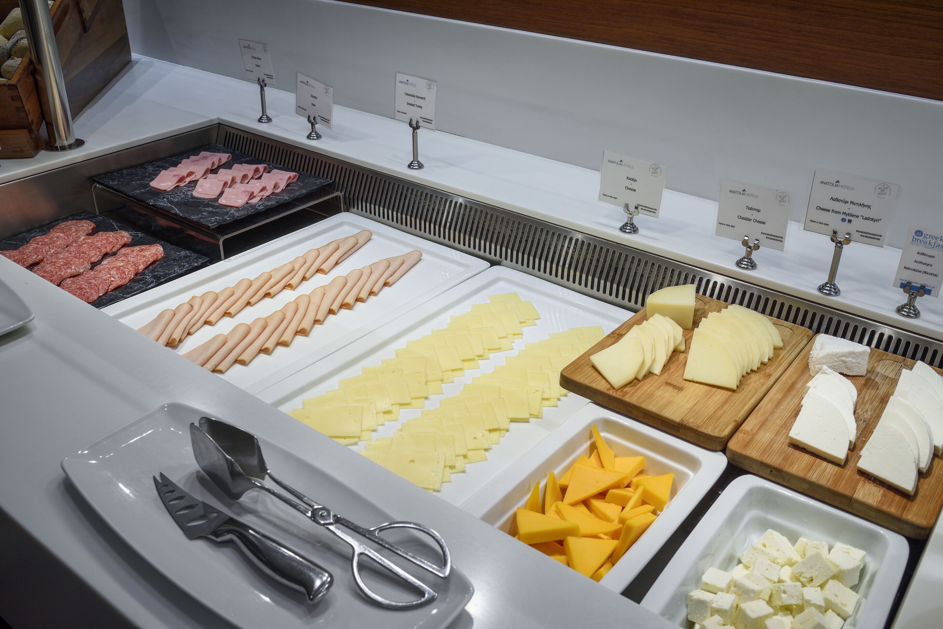 A buffet with various food options including meats, cheeses, and vegetables.