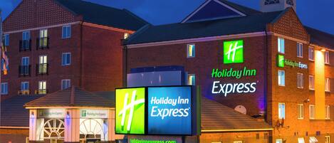 A Holiday Inn Express building with multiple signs and a brick facade.