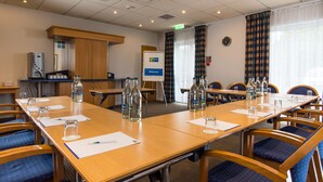 A conference room with a long table, chairs, and a whiteboard. There are bottles of water and glasses on the table. - Holiday Inn Express Newcastle Gateshead by IHG (Newcastle-upon-Tyne)