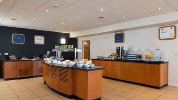 Un espace dédié au petit-déjeuner, comprenant un îlot central, un coin café et divers produits alimentaires.