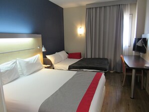A hotel room with two beds, a desk, a chair, a TV, and a window with curtains. - Holiday Inn Express Madrid-Alcorcón by IHG (Alcorcon)