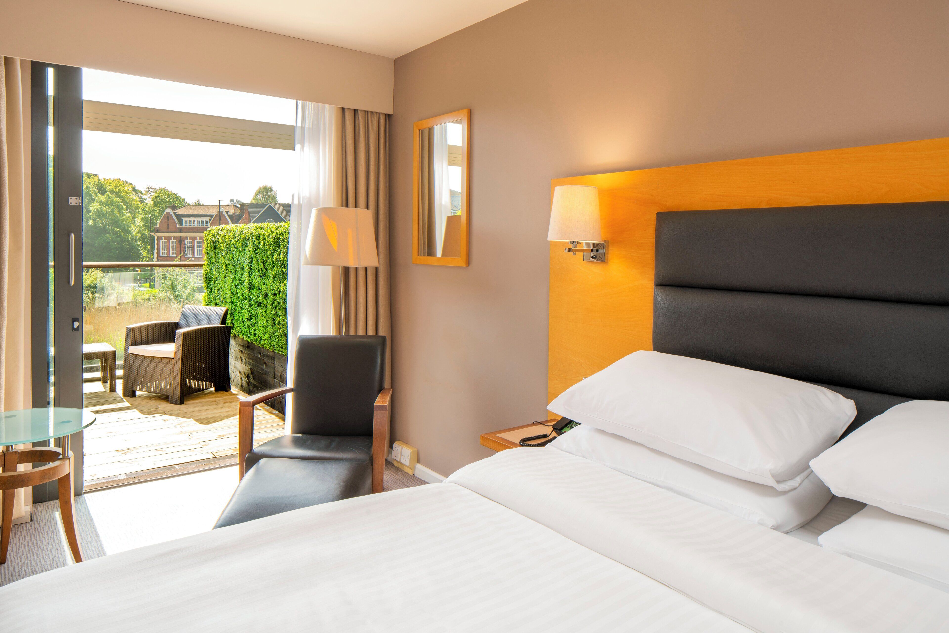 Una camera d'albergo con un letto, una sedia, un tavolo e vista sull'esterno.
