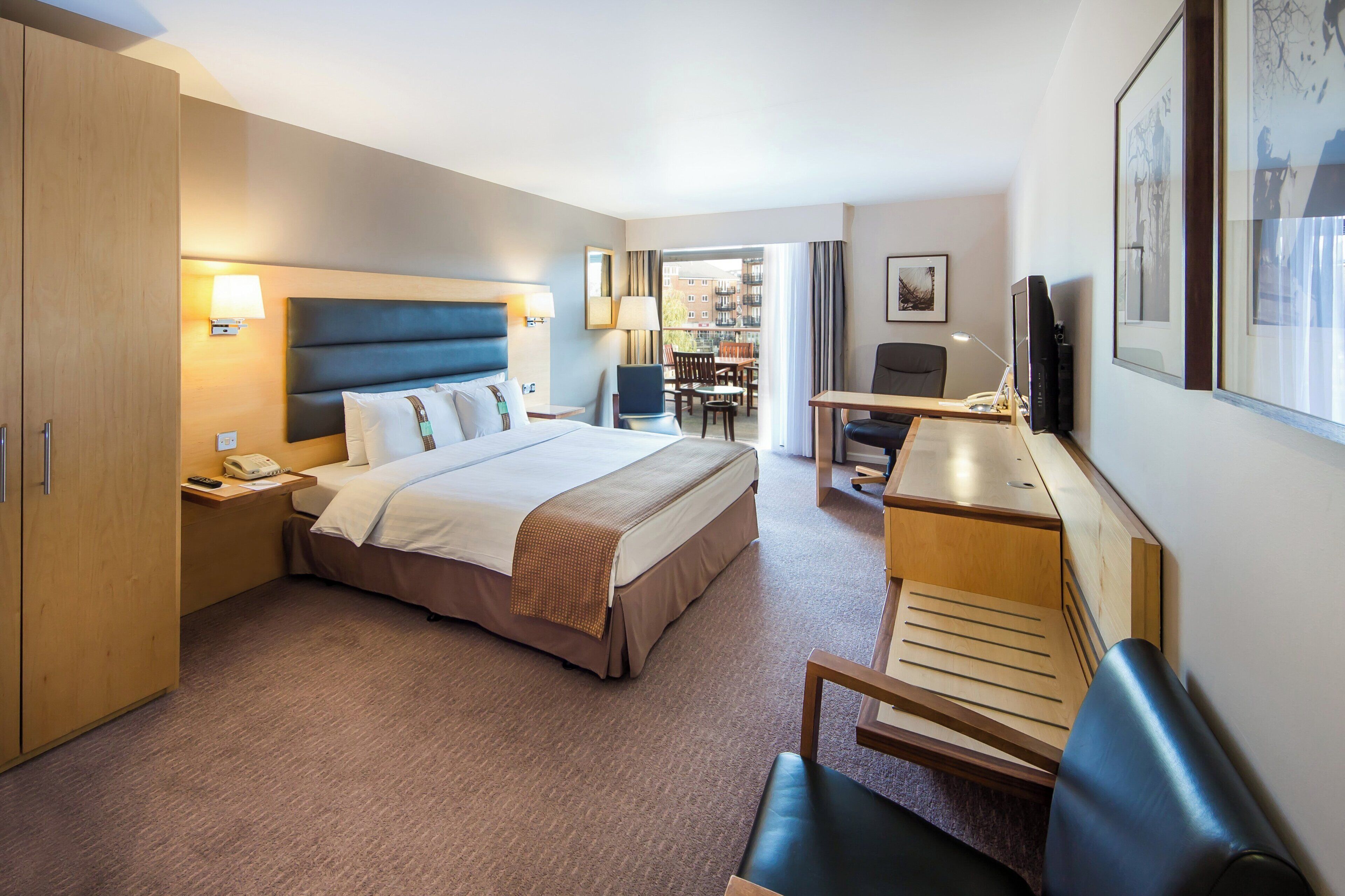 Een hotelkamer met een bed, bureau, stoel en uitzicht.