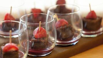 A series of clear glasses containing a dessert with a strawberry on top.