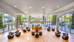 A spacious lobby with a reception desk, comfortable seating, and large windows offering views of the outdoors. - Ethra Reserve - Calanè 4* (Castellaneta)