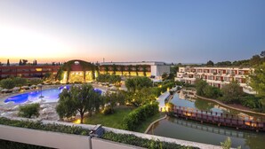 A hotel with a swimming pool, outdoor seating, and a bridge over a water feature. - Ethra Reserve - Calanè 4* (Castellaneta)