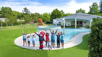 Guests can enjoy a fun day by the pool with a play structure and comfortable seating area nearby.