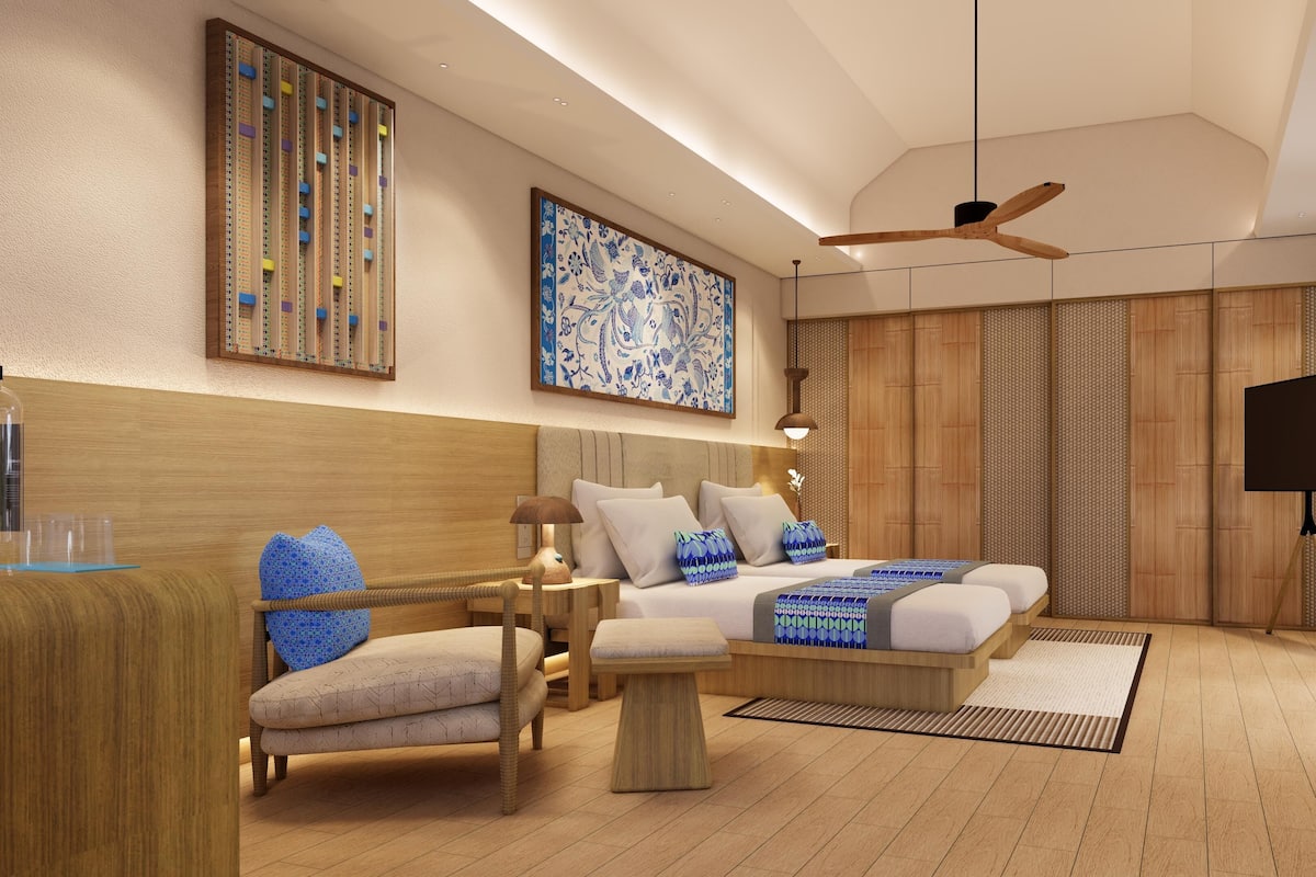 A modern bedroom with a bed, bedside tables, a chair, a desk, a television, and a ceiling fan.