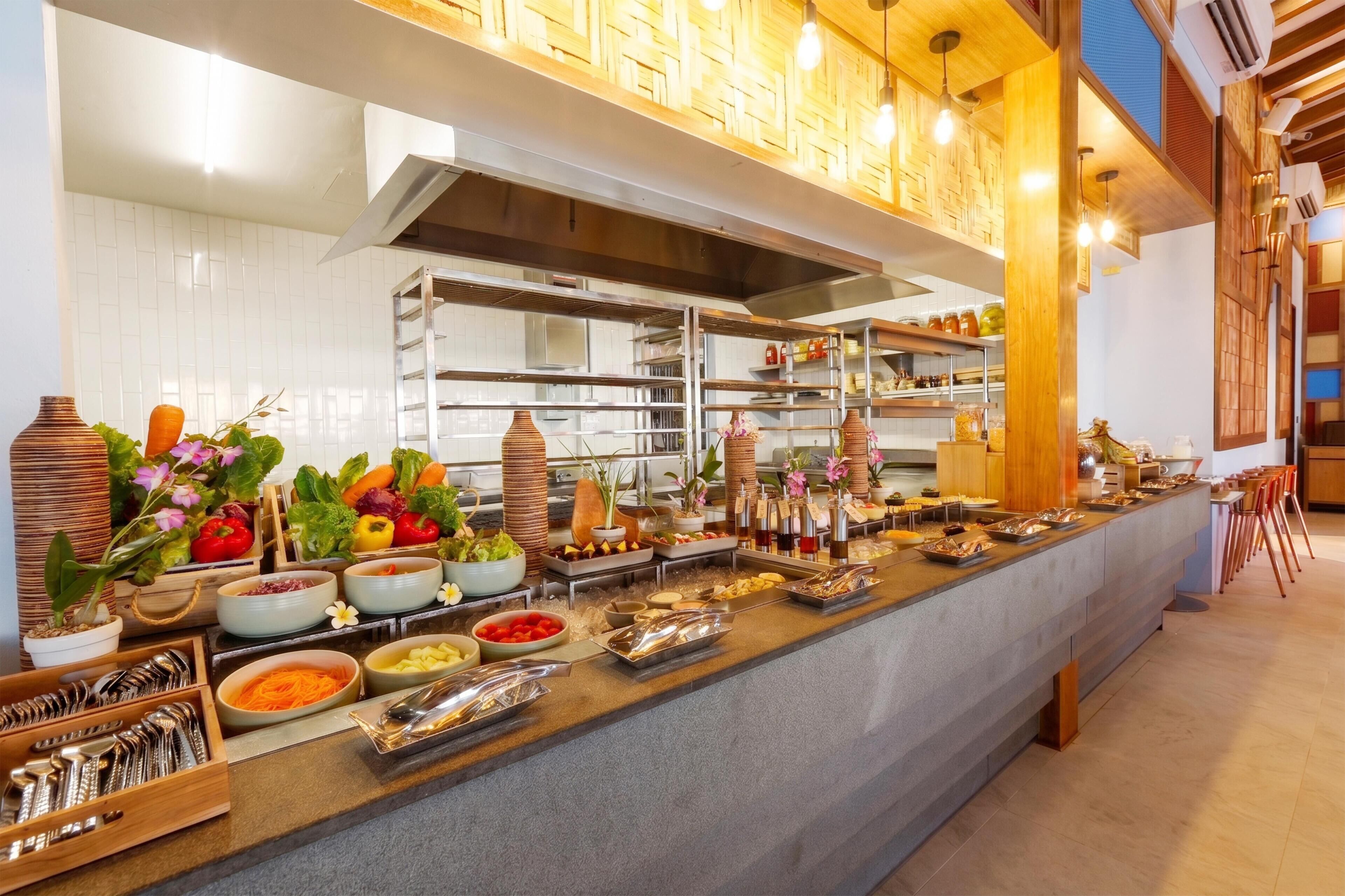 A buffet setup with various food items and utensils.