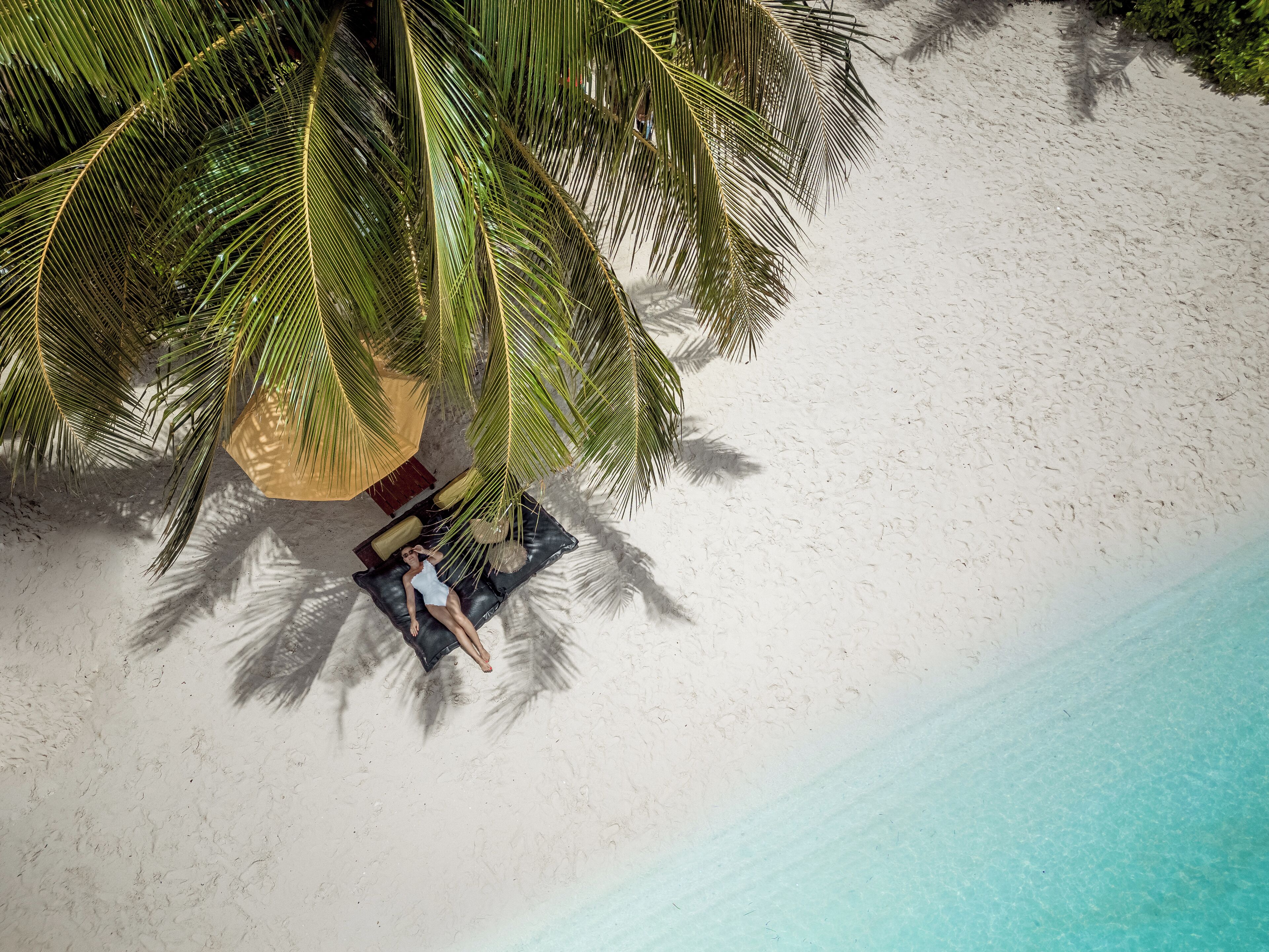 on the beach, white sand, beach umbrellas, beach towels