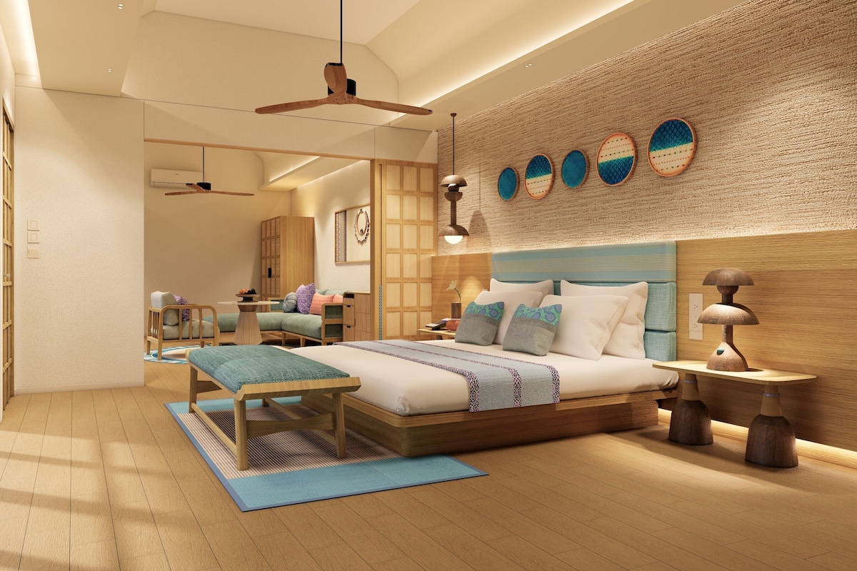 A modern bedroom with a large bed, a wooden headboard, a hanging light fixture, and a wall-mounted air conditioner.