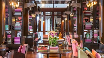 Ein gemütlicher Lounge-Bereich mit einem zentralen Tisch, Bücherregalen und bequemen Sitzgelegenheiten.
