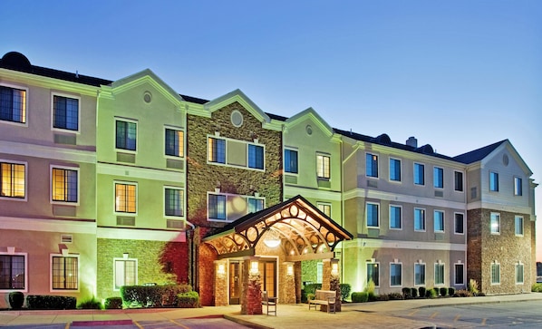 A multi-story hotel with a central entrance featuring a covered patio area. - Staybridge Suites O'Fallon Chesterfield by IHG (O'Fallon)