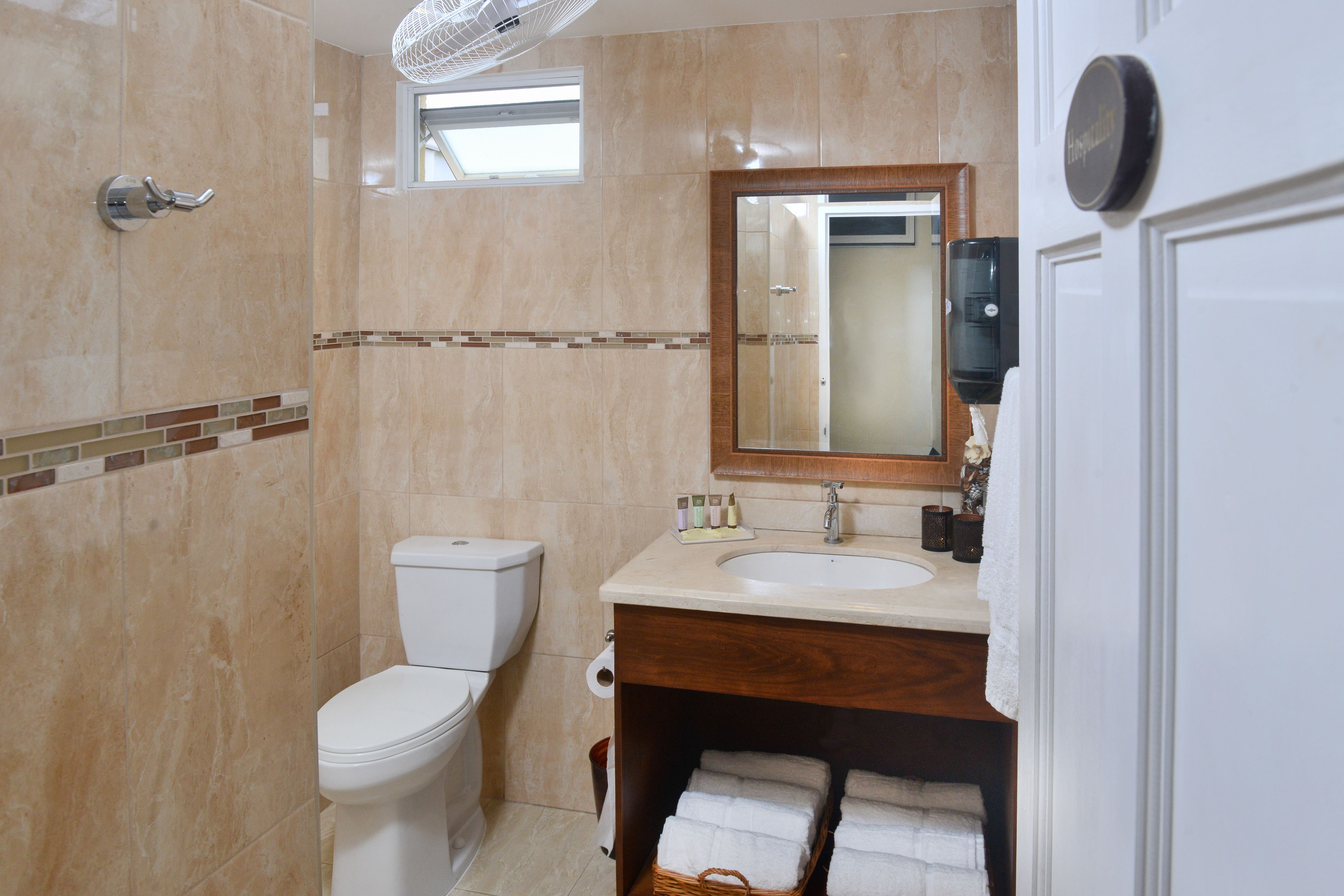 A bathroom with a toilet, sink, and mirror.