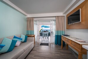 Suite junior, vistas al mar, junto a la piscina | Zona de estar | Una televisión