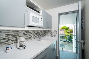 A modern kitchen with a coffee maker, microwave, and a view of the outside.